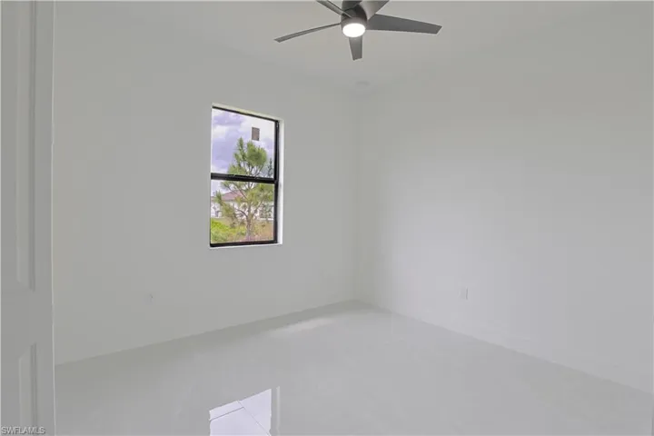 Empty room featuring baseboards and a ceiling fan
