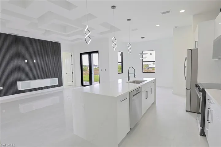 Kitchen featuring a center island with sink, a sink, white cabinets, modern cabinets, and appliances with stainless steel finishes
