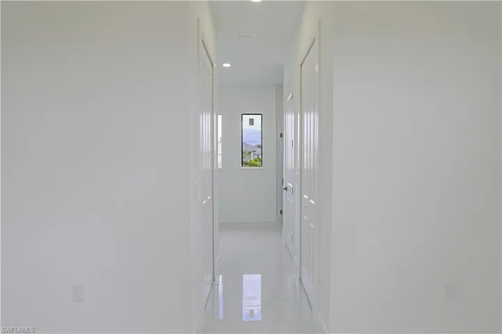 Hallway with baseboards and recessed lighting