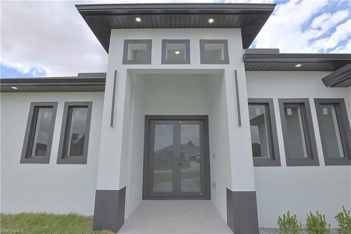 Property entrance with stucco siding and french doors