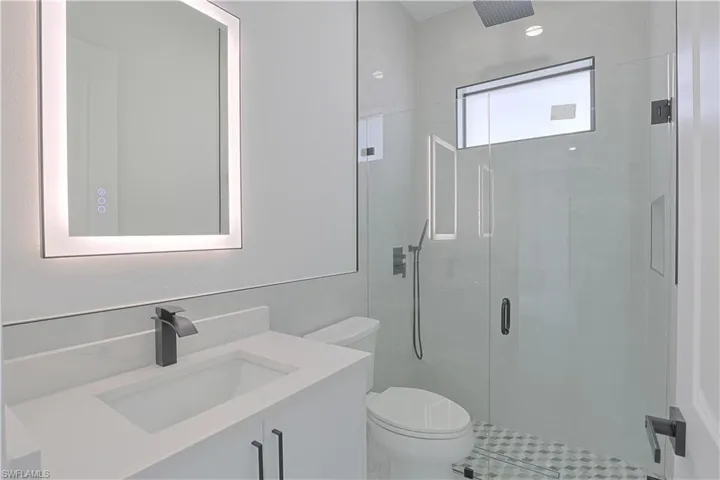 Bathroom with a shower stall, toilet, and vanity