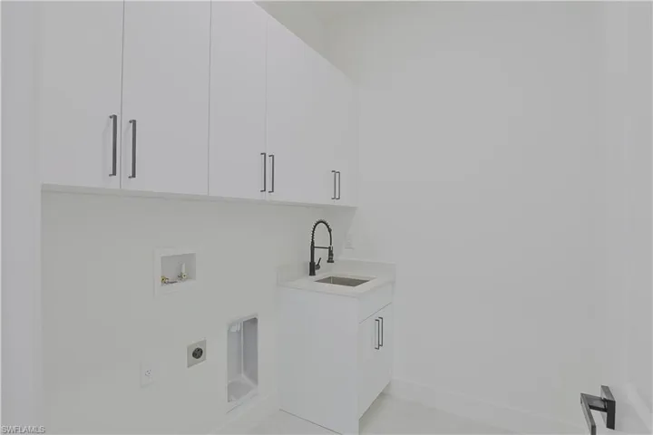 Laundry room featuring a sink, hookup for an electric dryer, baseboards, cabinet space, and hookup for a washing machine