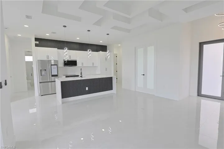 Kitchen with light countertops, visible vents, modern cabinets, appliances with stainless steel finishes, and white cabinetry