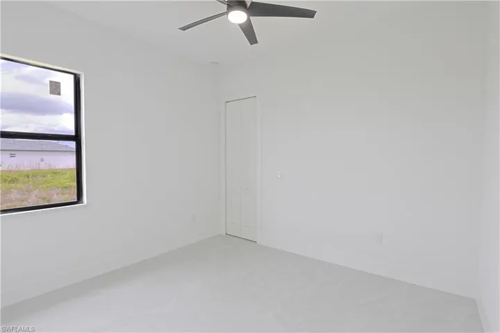 Unfurnished room featuring concrete floors, baseboards, and ceiling fan