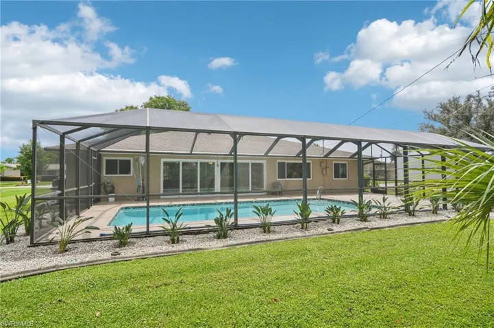 View of pool with a lanai, a patio, and a yard