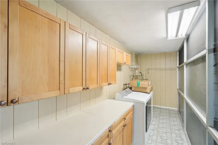 Laundry room with cabinets and washing machine,  dryer and sink.