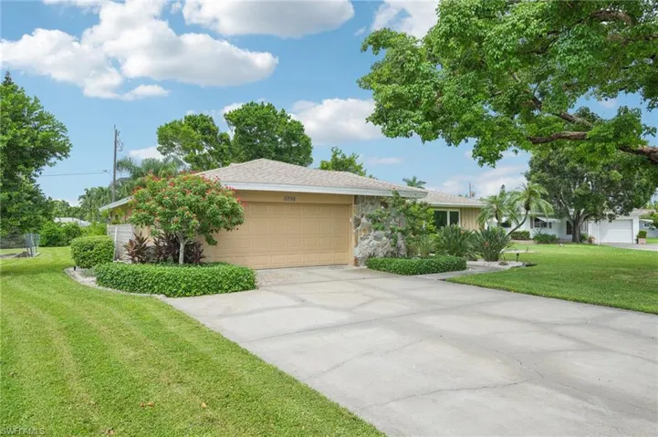 Ranch-style home featuring a front yard and a 2 car garage