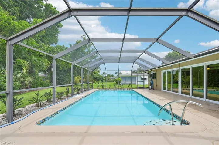 View of 30' x 20' pool featuring sliders to sun room and screened lanai and a patio area