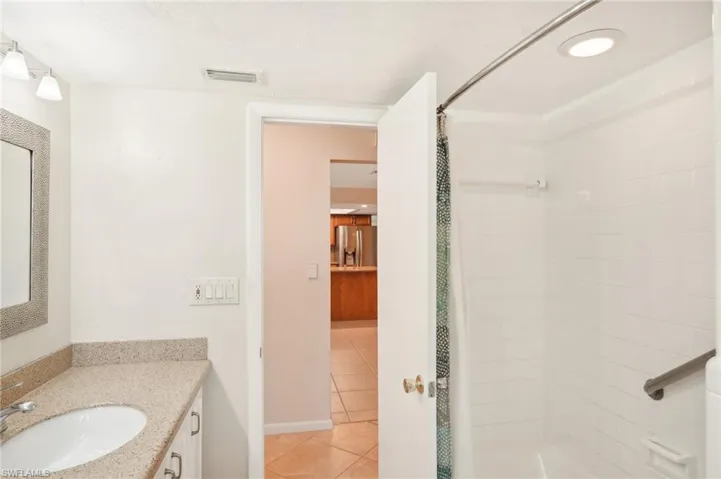 Bathroom featuring vanity, curtained shower, and tile patterned floors
