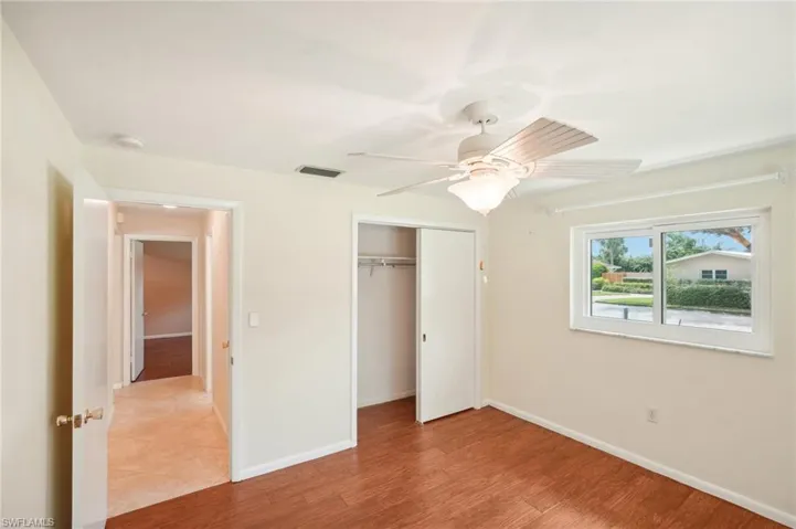 Unfurnished bedroom featuring light wood-type flooring, ceiling fan, and a closet