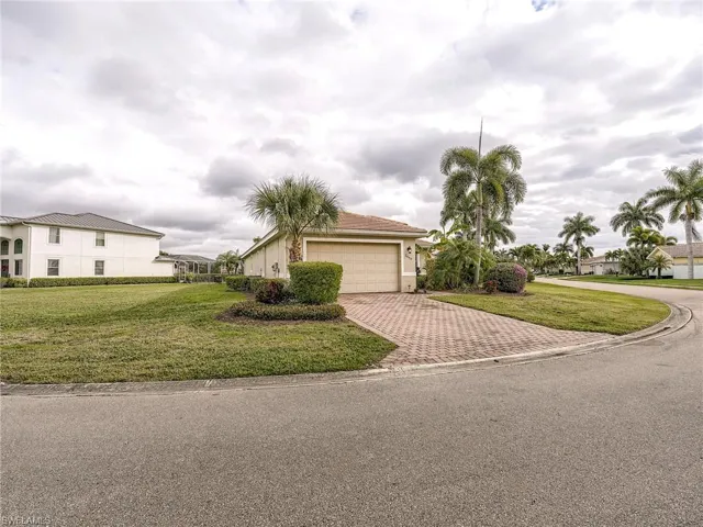 View of front facade featuring decorative driveway, a front lawn, and an attached garage