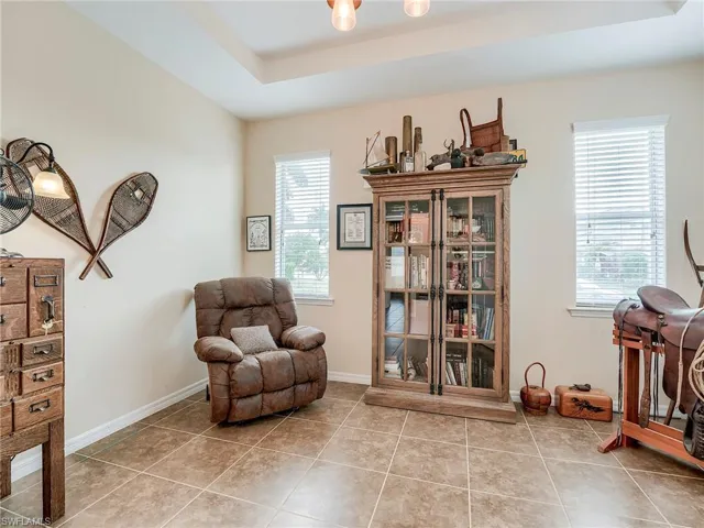 Sitting room featuring light tile patterned flooring and a tray ceiling