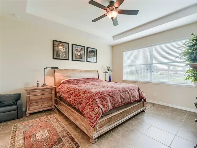 Bedroom featuring a tray ceiling and a ceiling fan