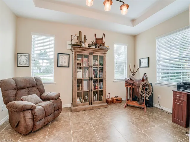 Living area featuring a raised ceiling, plenty of natural light, and light tile patterned floors