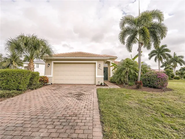 View of front facade with decorative driveway, stucco siding, a front yard, and an attached garage