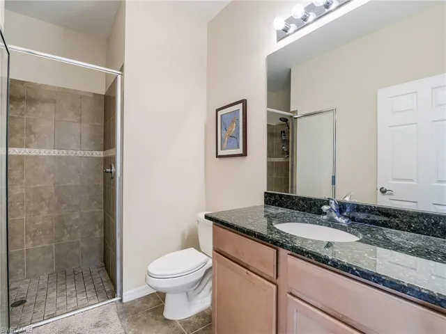 Bathroom featuring vanity, a shower stall, and light tile patterned flooring