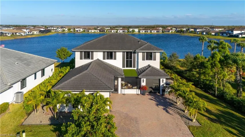 View of front of house with a water view, stucco siding, decorative driveway, and a residential view