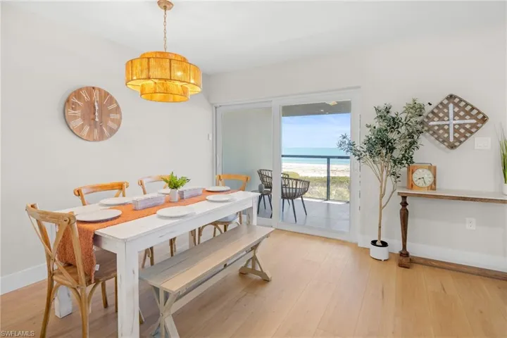 Dining space featuring light wood finished floors and view of water and beach