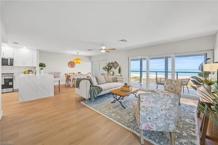 Living area with a water view, light wood-type flooring, and a ceiling fan