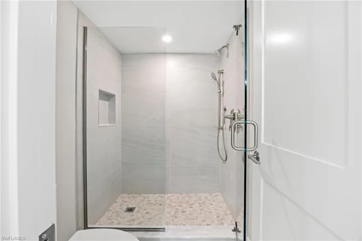 Bathroom featuring a shower stall and recessed lighting