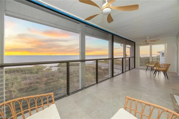 Sunroom featuring a ceiling fan and a water view