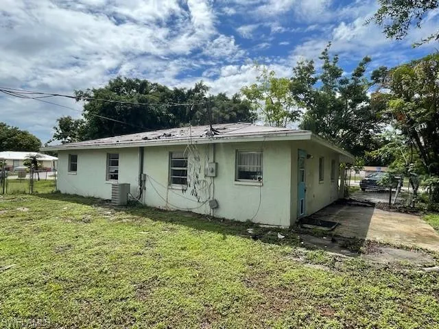 Rear view of house with a yard and central AC unit
