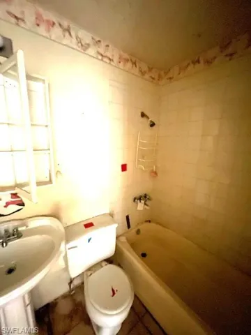 Full bathroom with sink, tile floors, toilet, and tiled shower / bath combo
