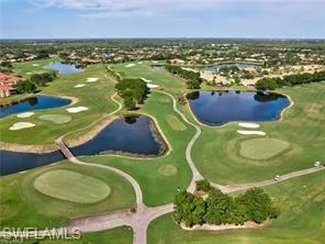 Expansive golf course with multiple water features, manicured greens, sand traps, and cart paths