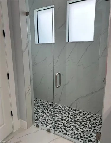 Bathroom with tile patterned floors and a shower with door