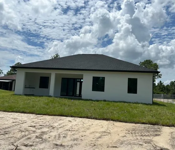 Rear view of house with a yard
