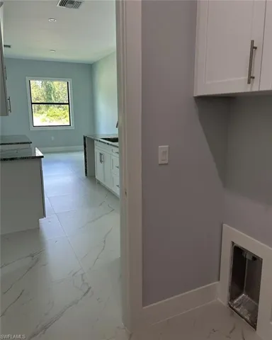 Laundry area featuring sink and light tile patterned floors