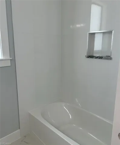 Bathroom with tile patterned floors and a bathtub