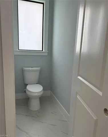 Bathroom with toilet and tile patterned flooring