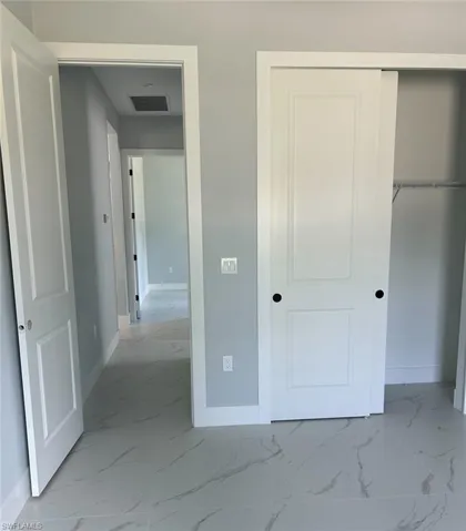 Unfurnished bedroom featuring a closet and light tile patterned flooring