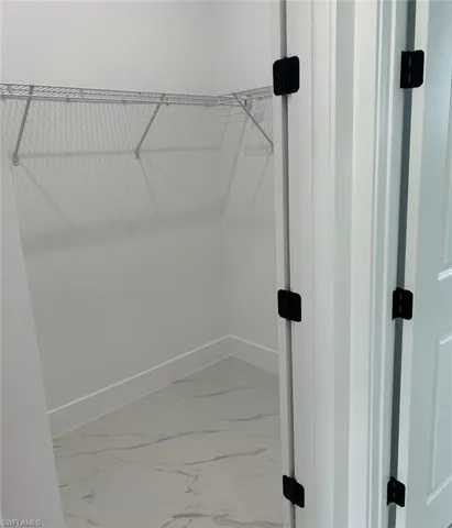 Walk in closet with tile patterned flooring