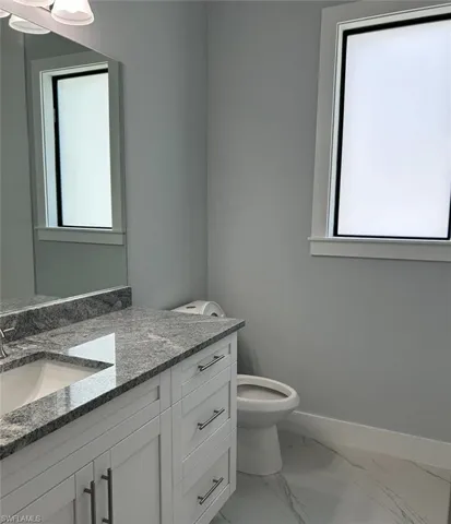 Bathroom with tile patterned floors, vanity, and toilet