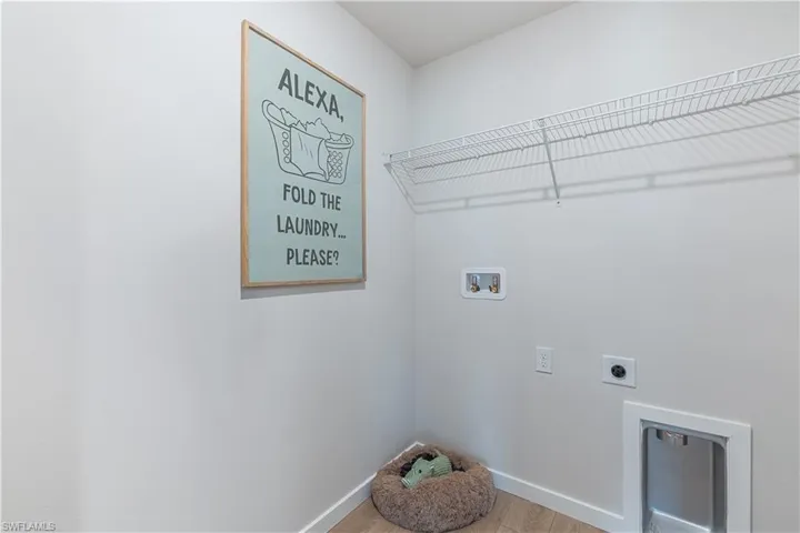 MODEL HOME - Laundry area with light wood-style flooring, hookup for an electric dryer, and hookup for a washing machine