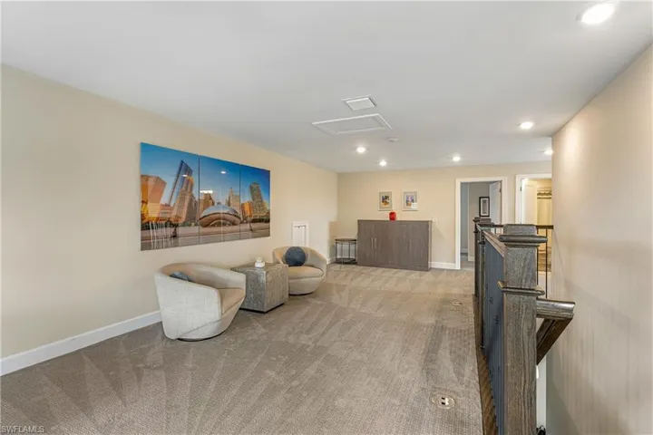 Sitting room with an upstairs landing, attic access, recessed lighting, and carpet floors