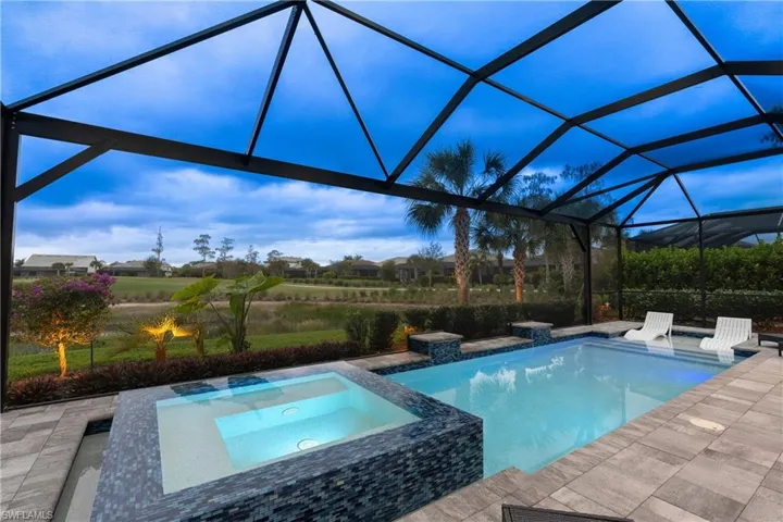 View of pool with a lanai, a pool with connected hot tub, and a patio