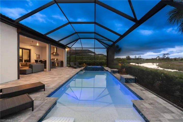 View of swimming pool featuring a patio area, a lanai, a pool with connected hot tub, and an outdoor hangout area