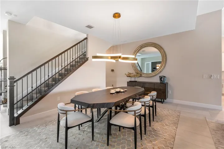 Dining space with stairs and light tile patterned floors