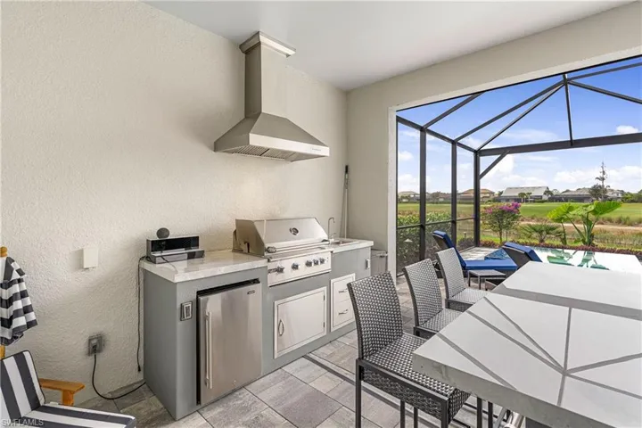 View of patio with a lanai, an outdoor kitchen, and outdoor dining space