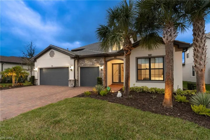 Ranch-style home featuring stucco siding, decorative driveway, an attached garage, a front yard, and stone siding