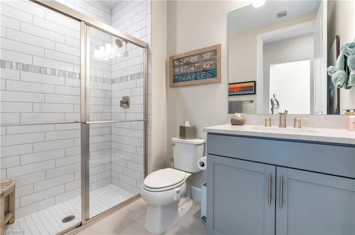 Bathroom with vanity, a shower stall, and light tile patterned floors