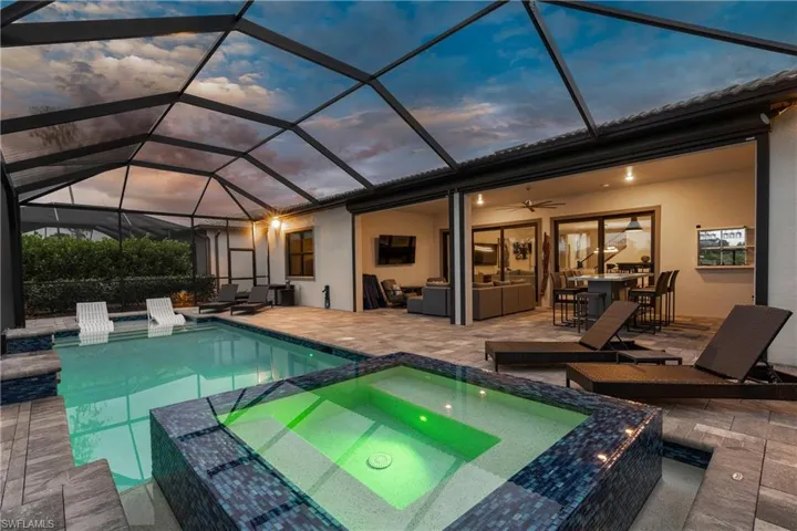 View of pool featuring a lanai, a patio, and a pool with connected hot tub