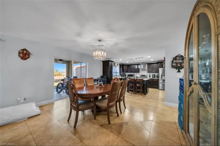 Dining area featuring a chandelier, light tile patterned flooring, recessed lighting, and a ceiling fan