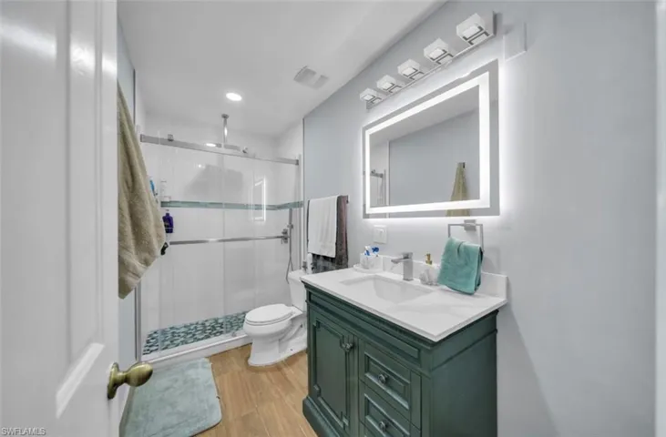 Full bath featuring vanity, a shower stall, light wood-style floors, and recessed lighting