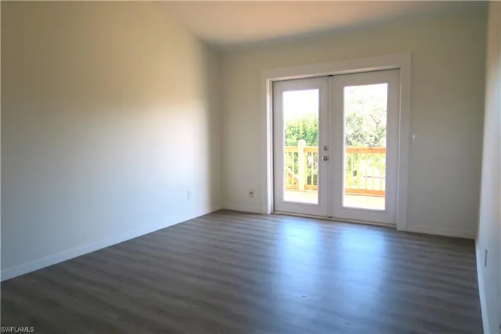 Spare room featuring dark wood-type flooring and french doors