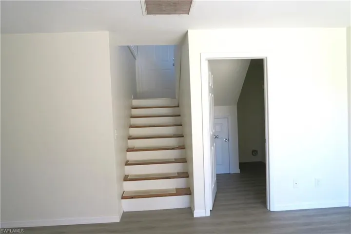 Staircase featuring wood finished floors and baseboards