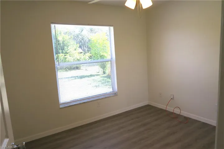 Spare room featuring dark wood finished floors and ceiling fan